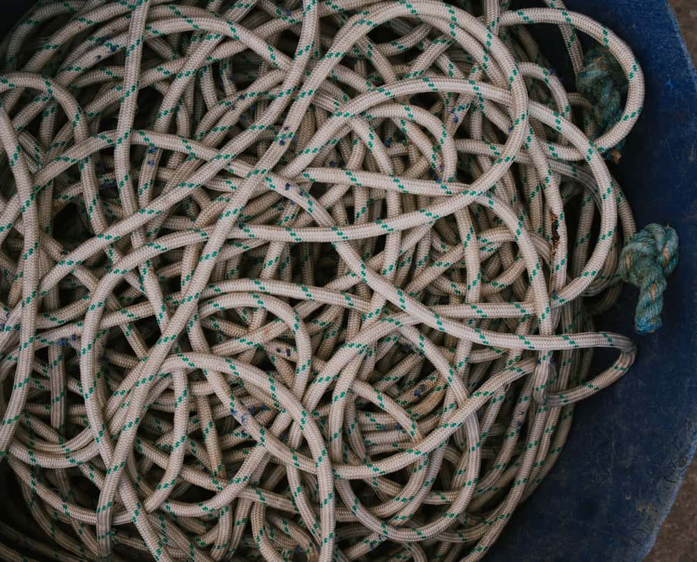 A coiled orange extension cord on concrete.