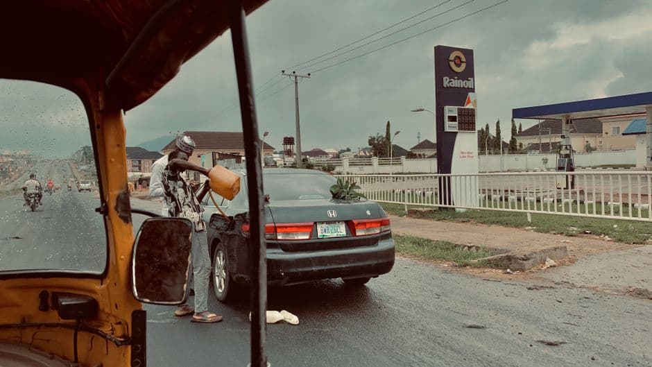A person filling a fuel container at a gas station.