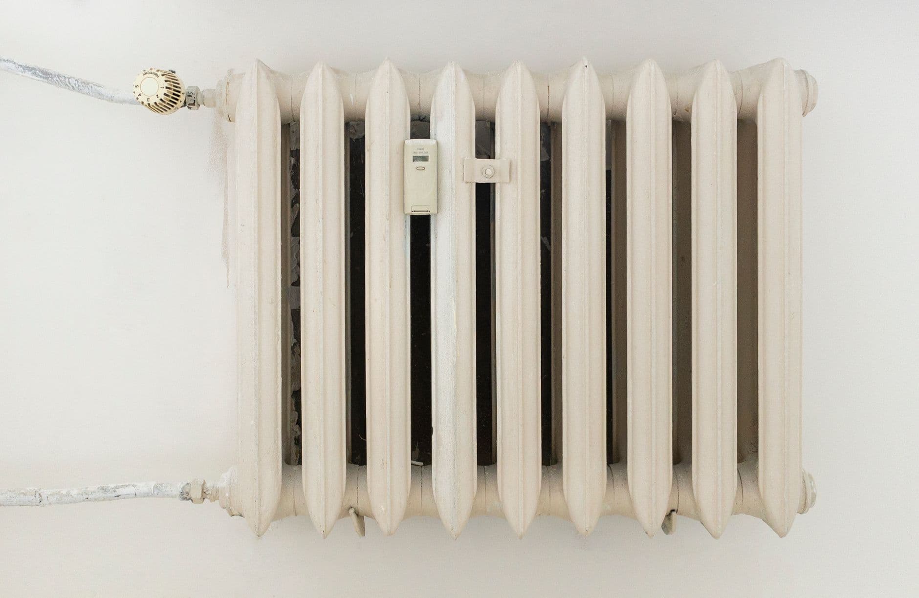 A white metal radiator on a plain wall.