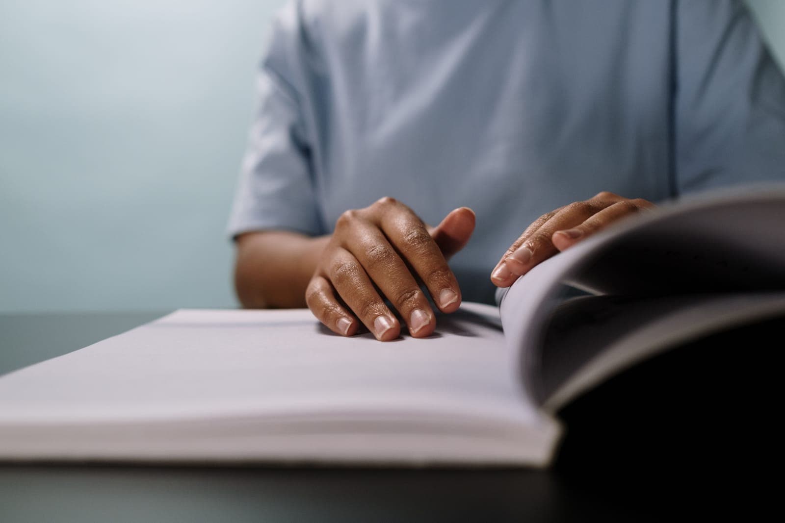 A person reading an instruction manual at a table.