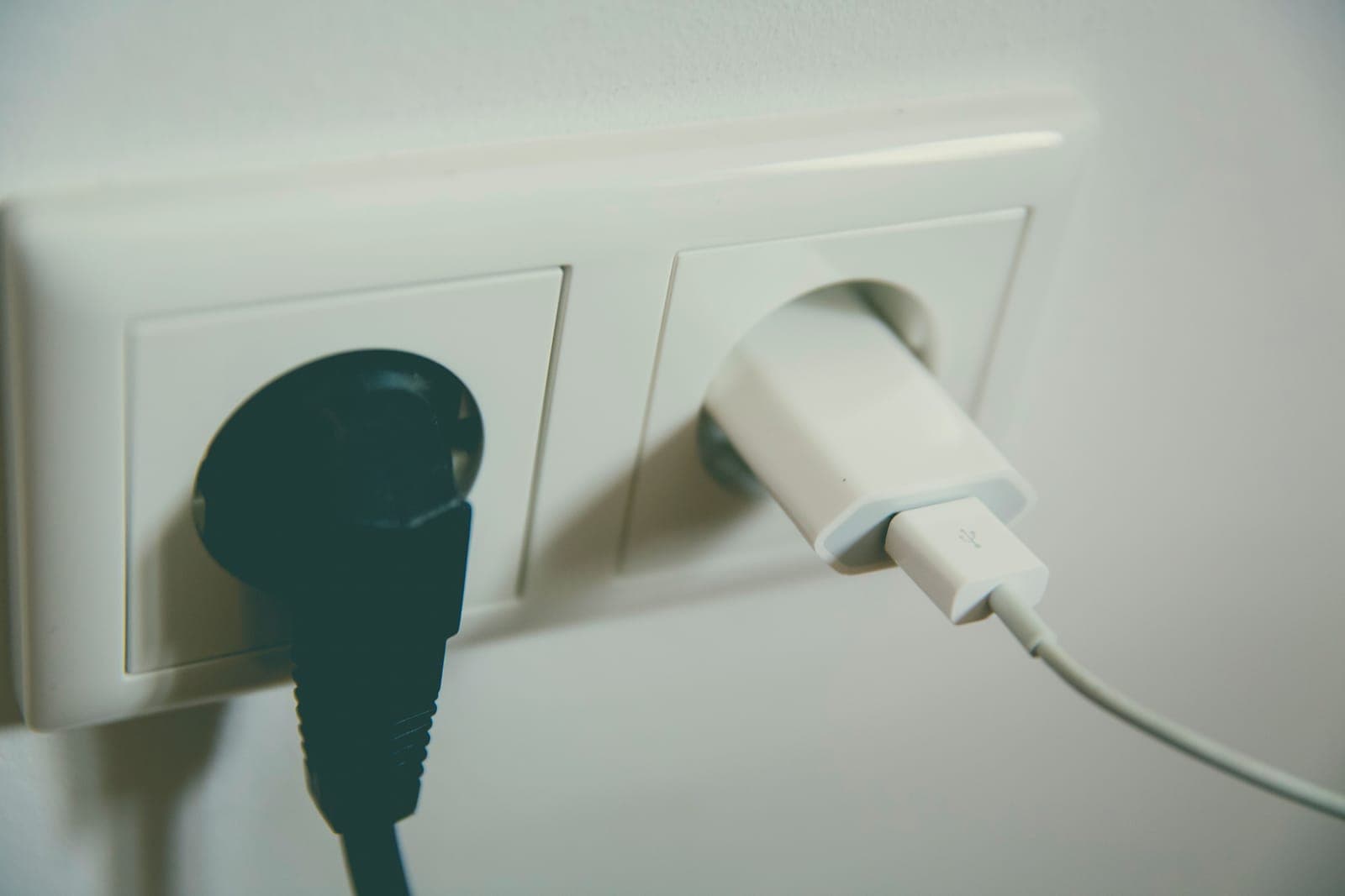 A charging cable plugged into a wall outlet.