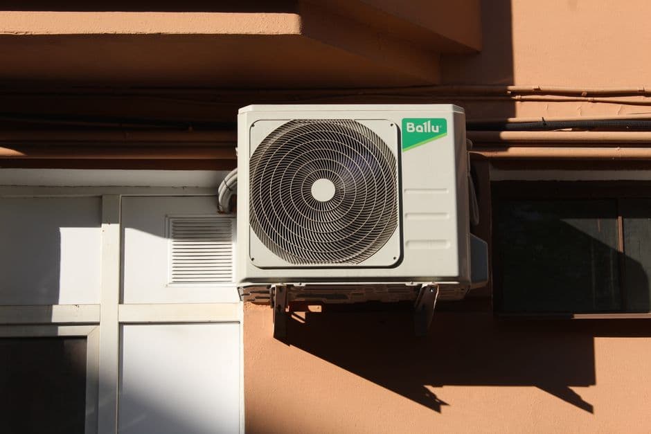 An air conditioner condenser unit mounted outside a building.