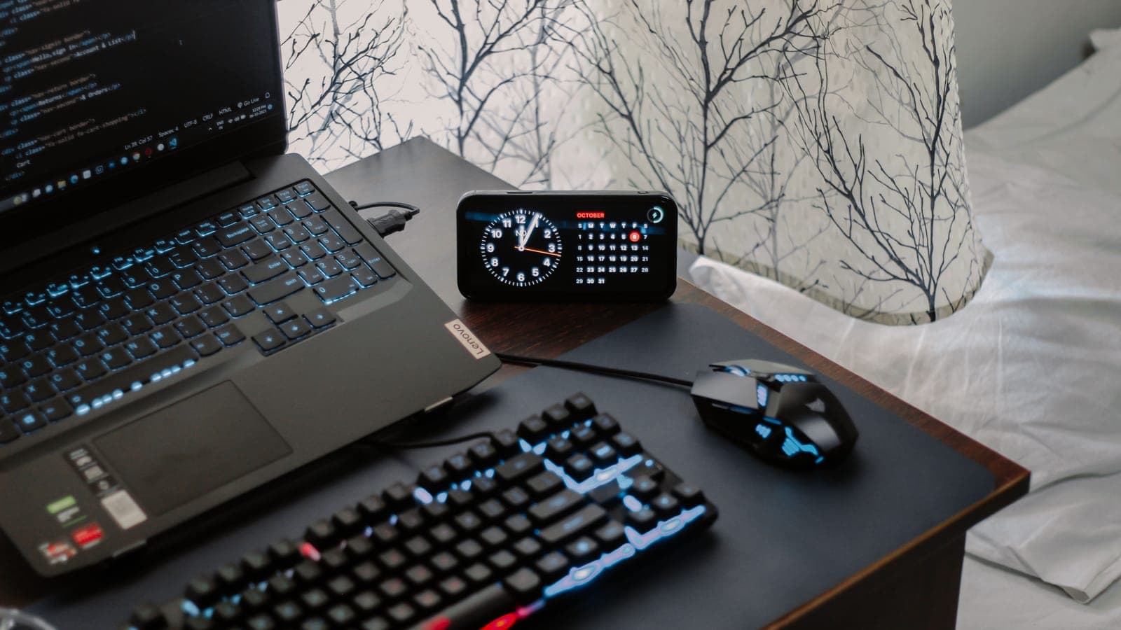 A calendar and a clock on a dark desk.