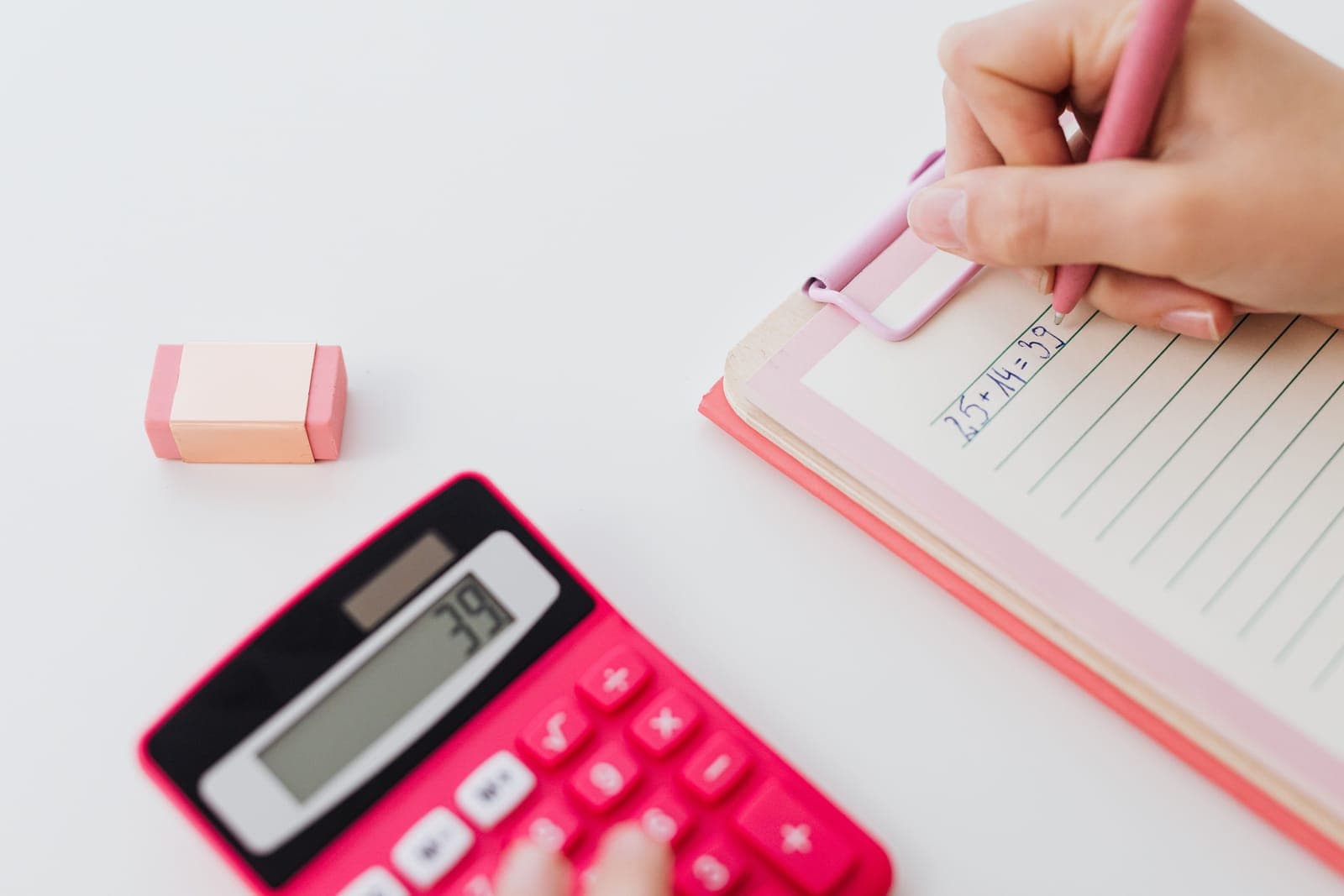 A notebook with calculations and a pen on a desk.