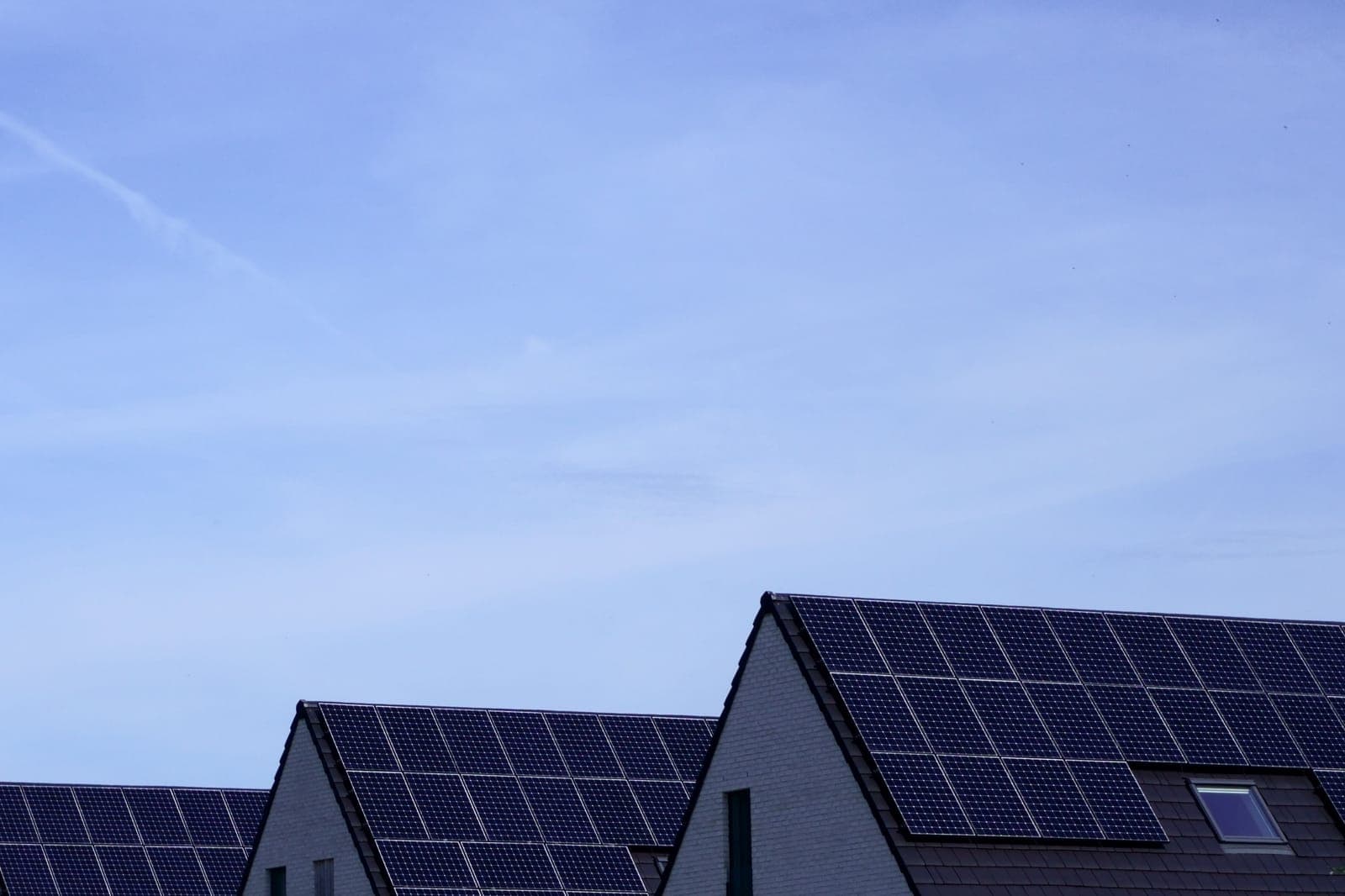 Rooftop solar panels against a blue sky.