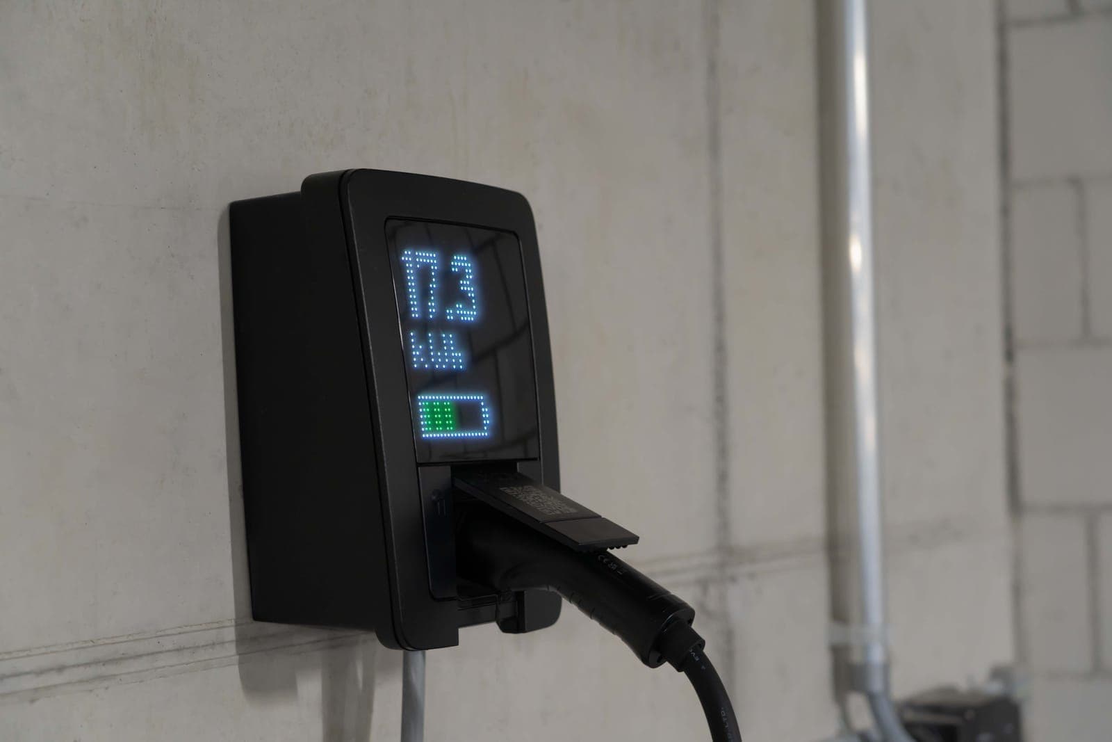 A home battery unit mounted on a garage wall.